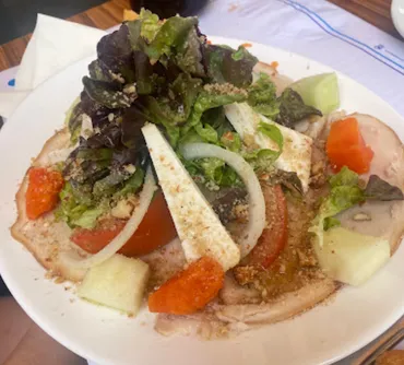 A Canarian salad of tomato, onion, lettuce and white cheese, dressed and sprinkled with gofio